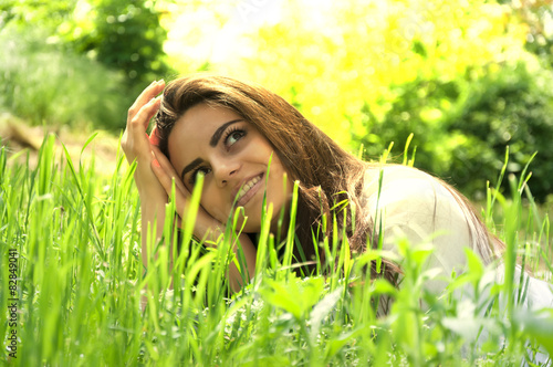 Beautiful girl in white enjoys the grass