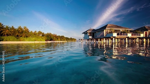 Panning view of the over water villas and tropical island photo