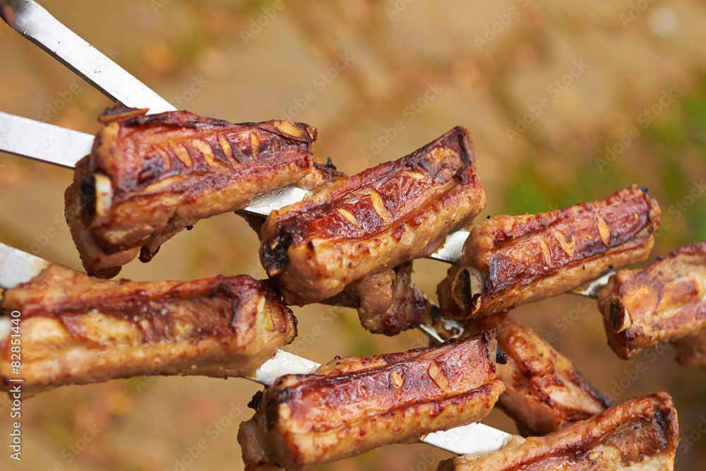Three skewers with grilled ribs on nature