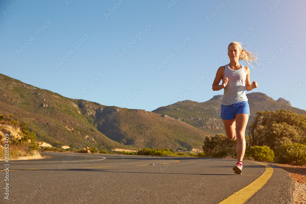 Young woman running on an empty road