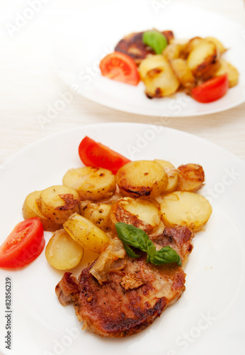 Grilled pork steak swith grilled potato and fresh tomato 