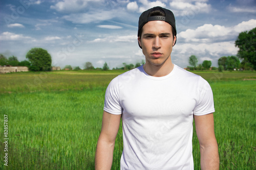 Handsome fit young man at countryside, wearing white t-shirt  photo