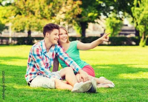 smiling couple sitting on grass in park © Syda Productions