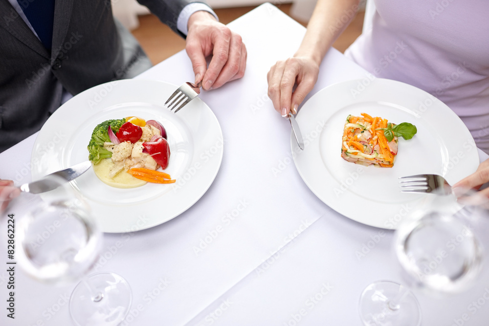 close up of couple eating appetizers at restaurant close up of couple eating appetizers at restaurant