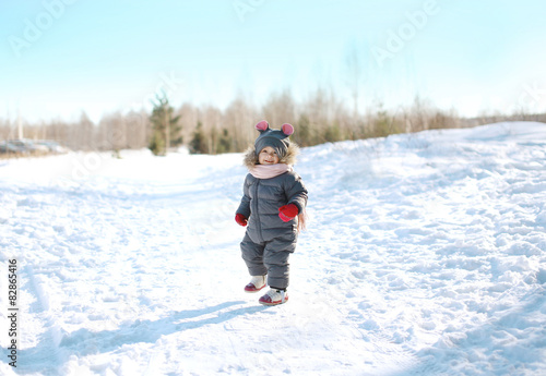 Happy child walking in sunny winter day