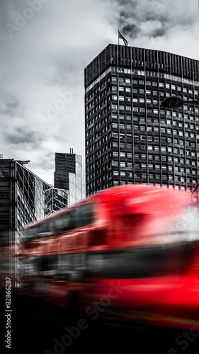 Fahrender Roter Bus vor Wolkenkratzer