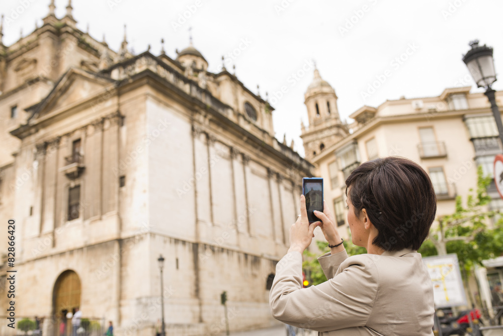 City photo. Woman taking cathedral picture image.