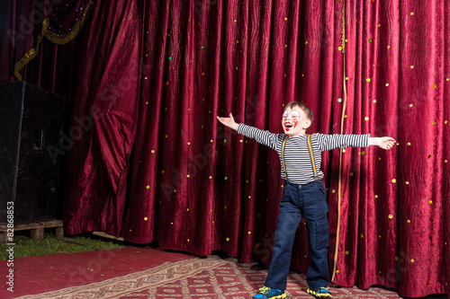 Laughing confident little boy on stage