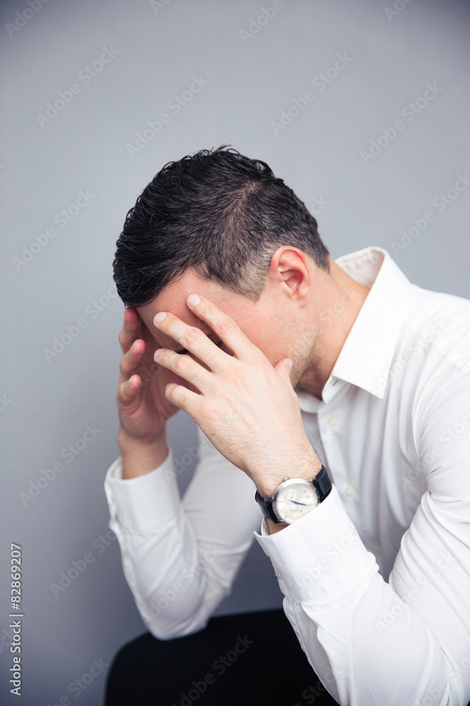 Depressed businessman over gray background Depressed businessman over gray background