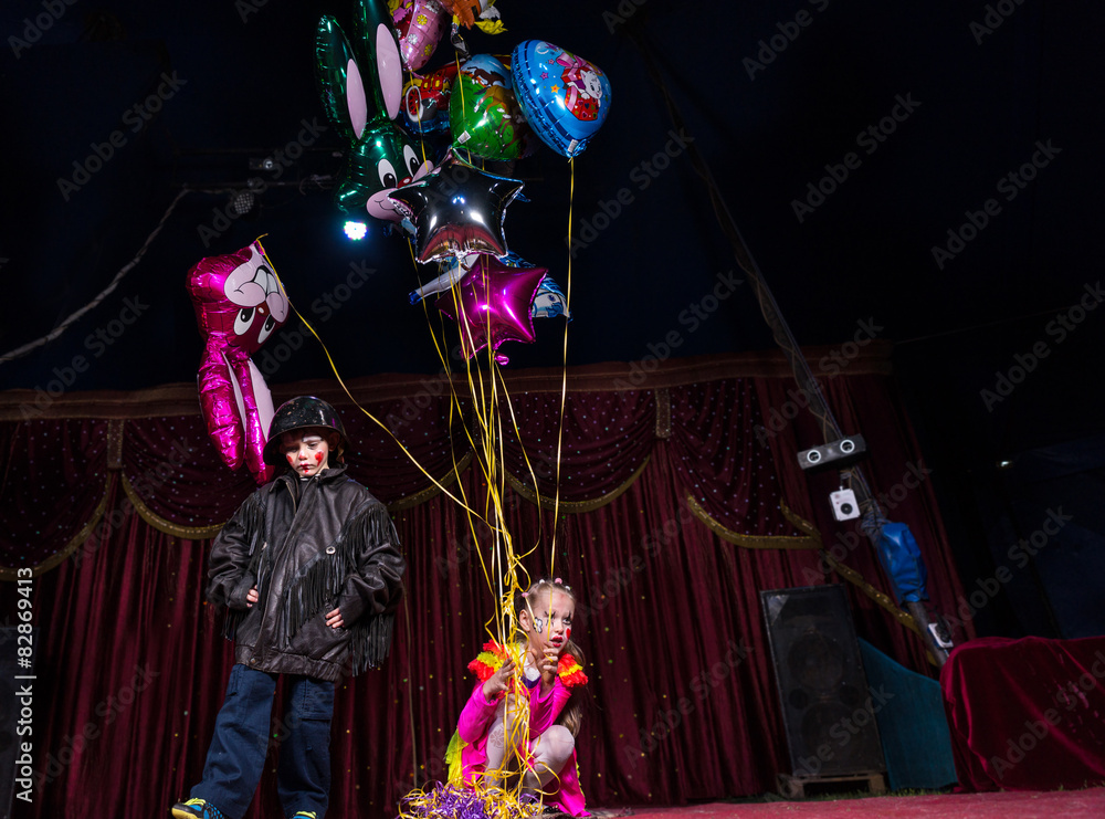 Boy Clown on Stage with Girl Holding Balloons