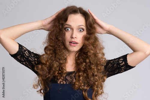 Surprised woman with long curly hair
