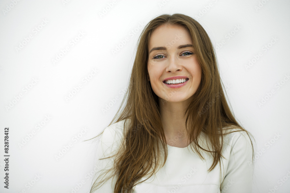Beautiful young happy woman posing against a white wall Beautiful young happy woman posing against a white wall