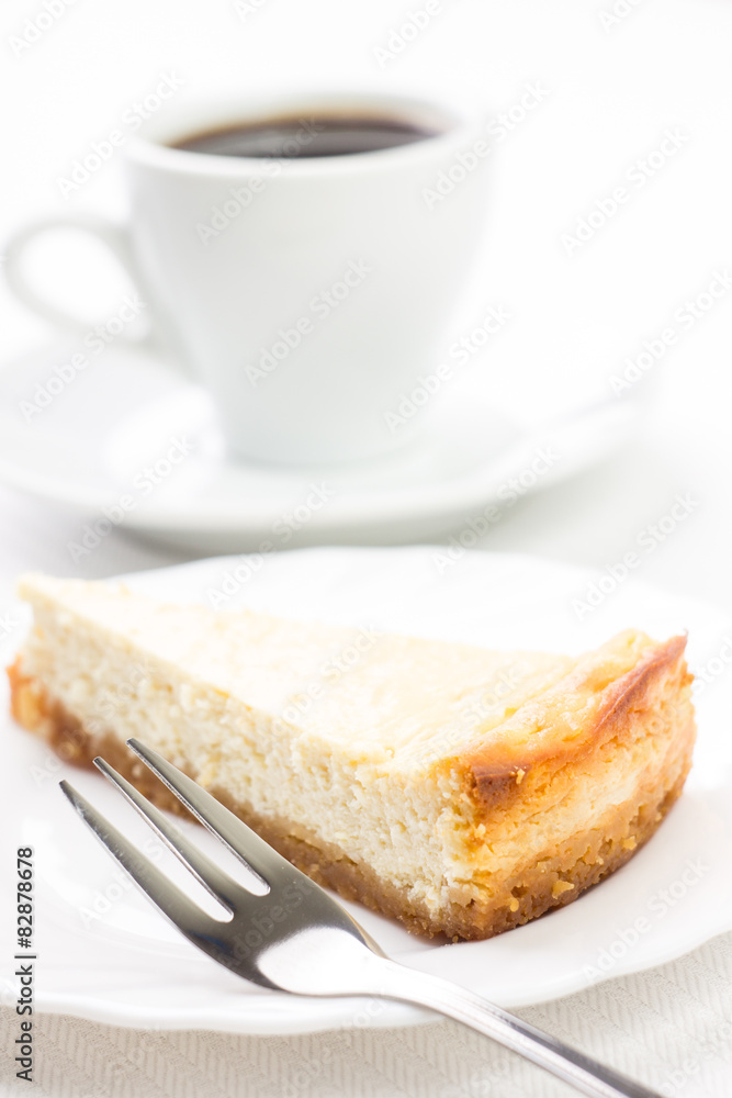 Wedge of cheesecake with dessert fork and cup of coffee Wedge of cheesecake with dessert fork and cup of coffee