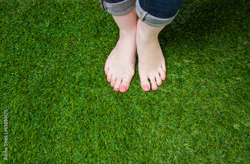 Woman legs in jeans standing on grass