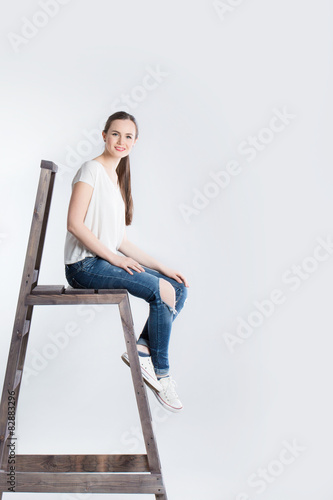 Cute woman with long hair sitting on the stairs