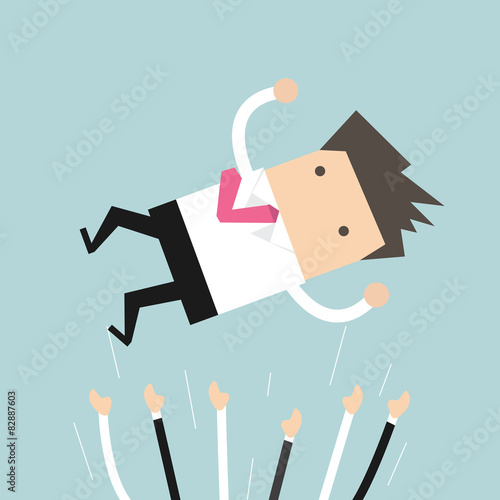 Successful businessman being throwing up in the air