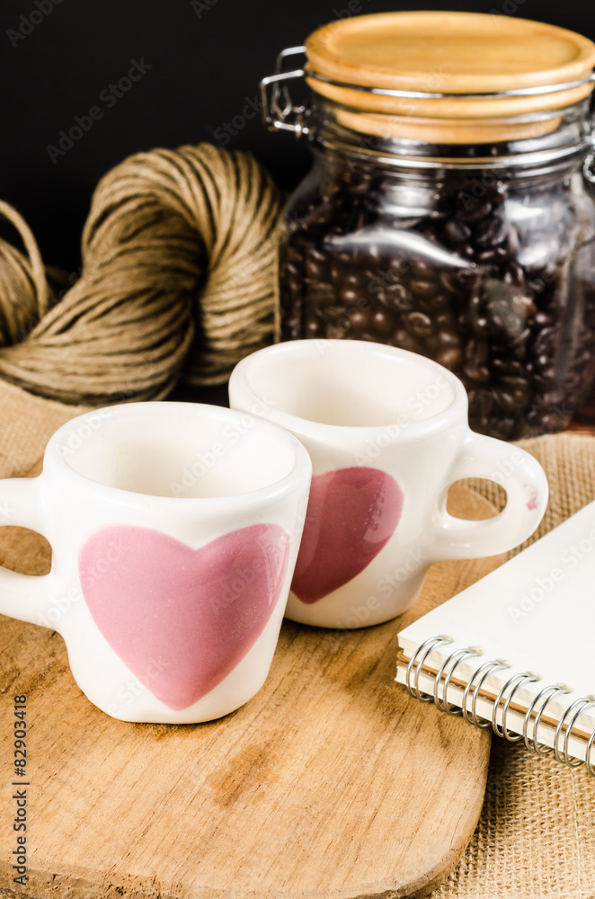 Two coffee cup on wooden board and coffee bottle with back backg Two coffee cup on wooden board and coffee bottle with back backg