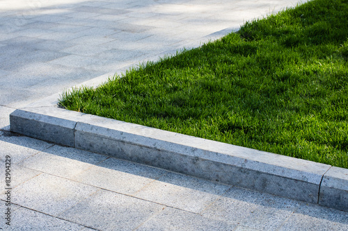 Trim the lawn in the park on the sidewalk