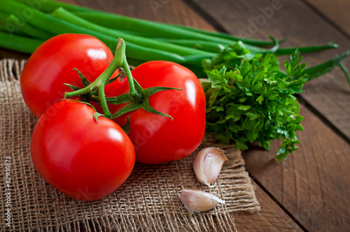 Branch of fresh tomato on wooden background