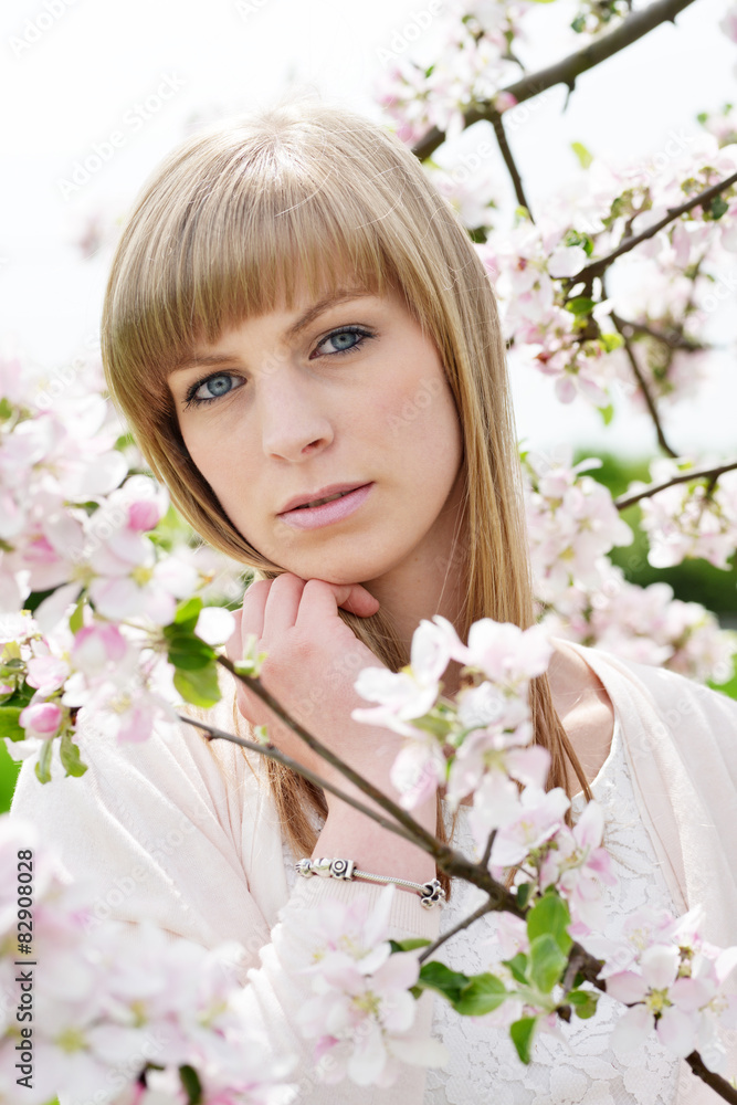 Fototapeta premium blonde Frau inmitten von zarte Blüten