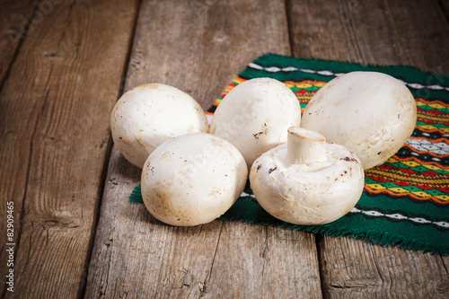 Fresh Organic mushrooms champignons on wooden background 