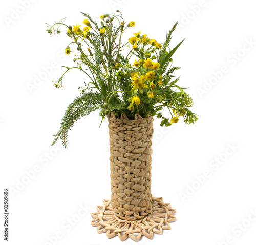 Wild flowers in a wicker vase isolated on white background
