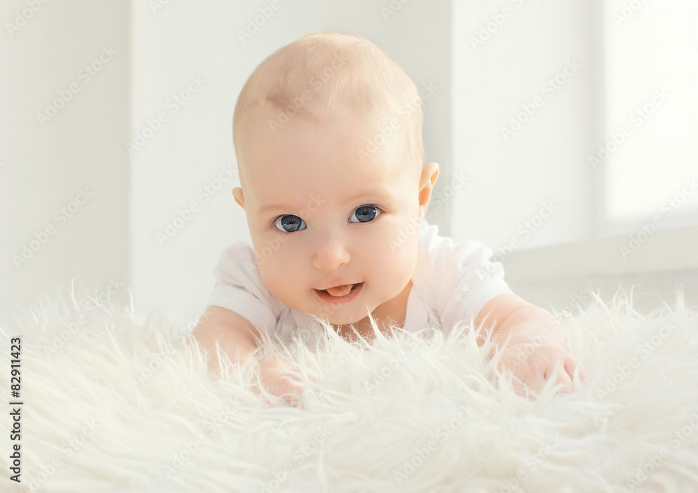 Closeup portrait of infant lying at home in white room near wind Closeup portrait of infant lying at home in white room near wind