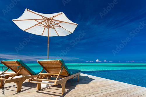 Deck chairs overlooking infinity pool and tropical lagoon © Martin Valigursky