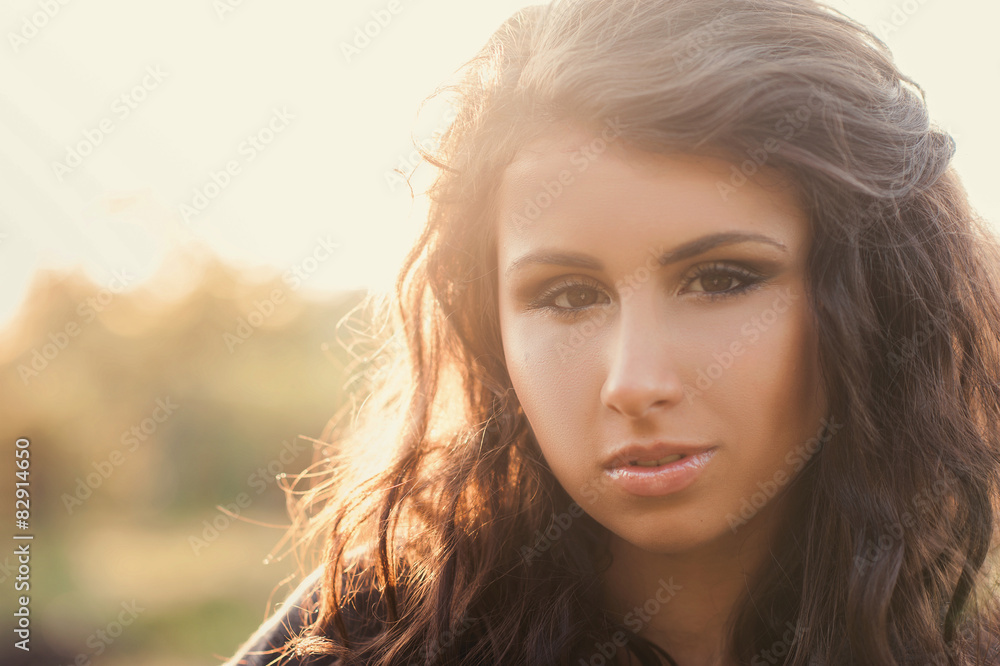 Fototapeta premium Portrait of a beautiful young girl in the sunlight