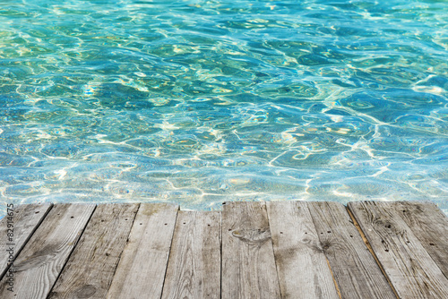 Empty wooden table to tropical blue water background