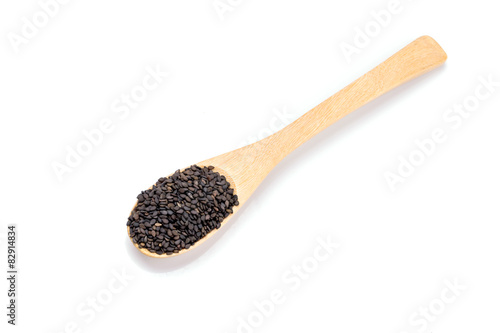 Heap of black sesame on wooden spoon