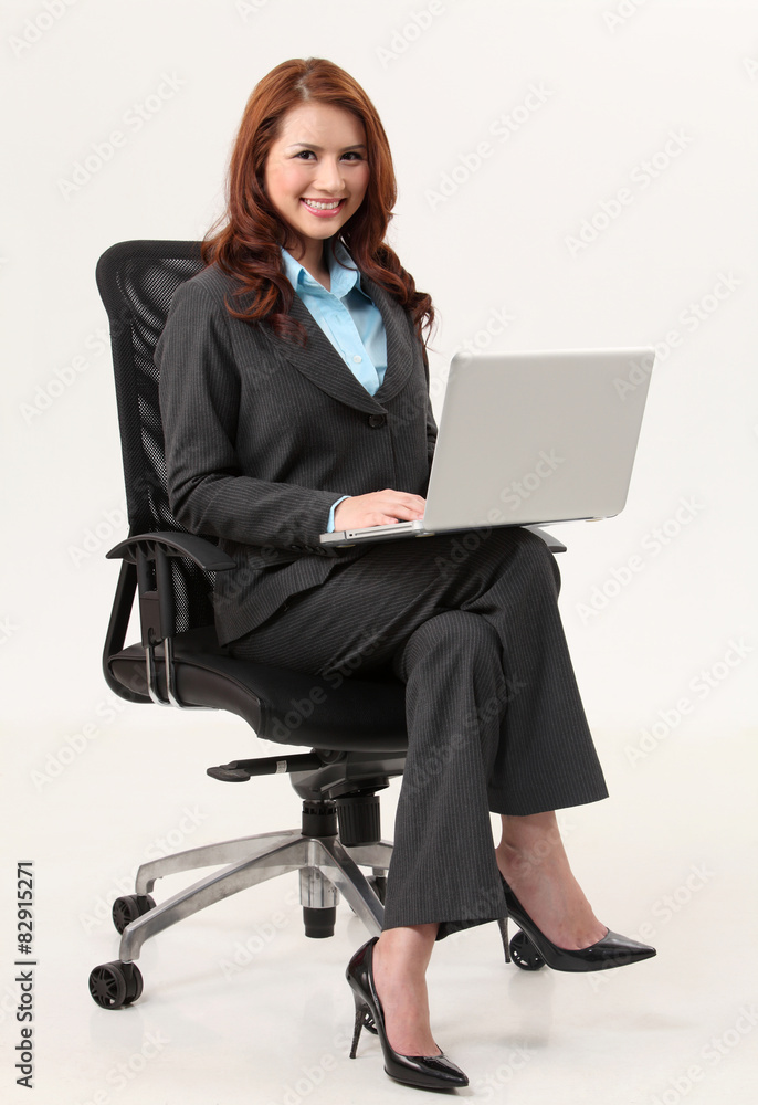 businesswoman sitting on the office chair holding a laptop businesswoman sitting on the office chair holding a laptop