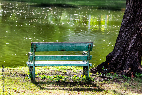 Foto Bench at waterfront and under shade trees in public Park,reflect