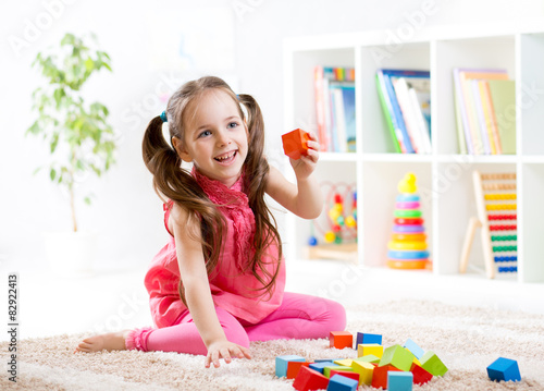 little girl playing on floo...
