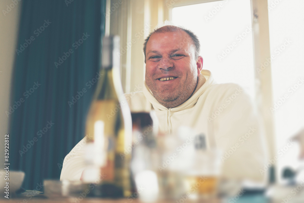 Happy middle-aged man sitting at a dining table Happy middle-aged man sitting at a dining table