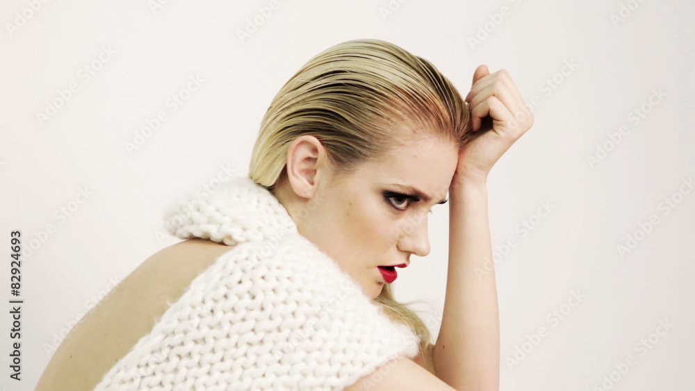 Beautiful Fashion Model In Glamorous White Woolen Dress Posing On White Cube Box Beautiful Fashion Model In Glamorous White Woolen Dress Posing On White Cube Box