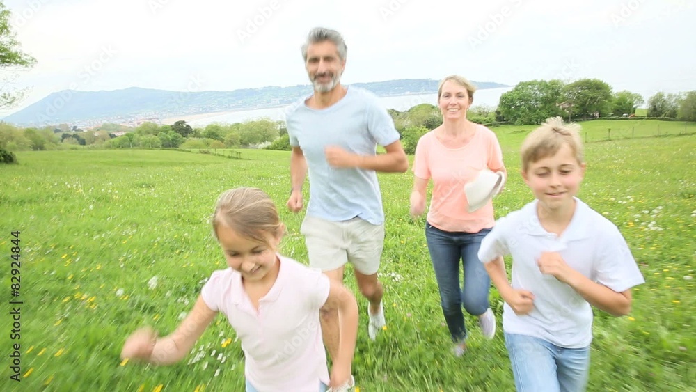 Family of four running in countryside