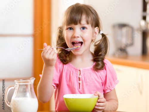 child eating healthy food in kitchen
