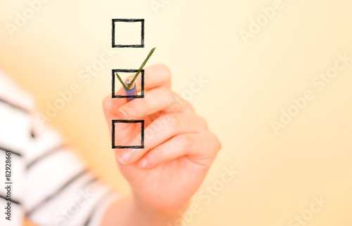Hand putting check mark with pen