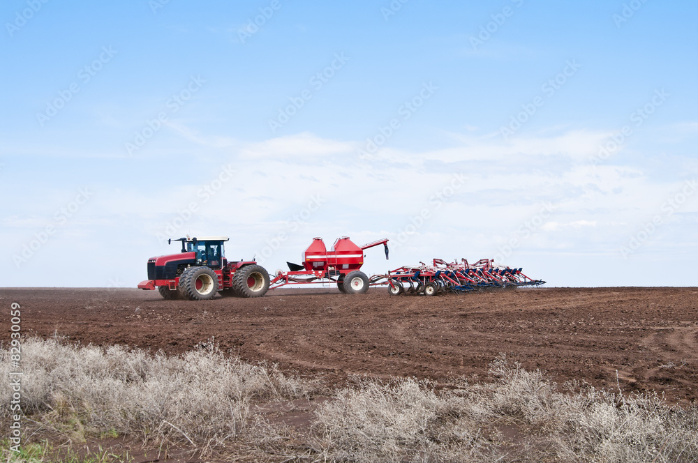 Fototapeta premium Traktor kołowy z siewnikiem