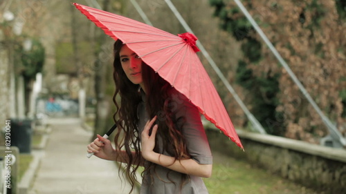 Fashion Model With Long Curly Hair Poses With Traditional Red Japanese Umbrella photo