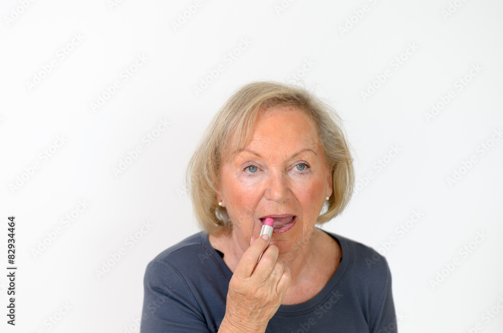 Attraktive ältere Rentnerin schminkt sich ihre Lippen Attraktive ältere Rentnerin schminkt sich ihre Lippen