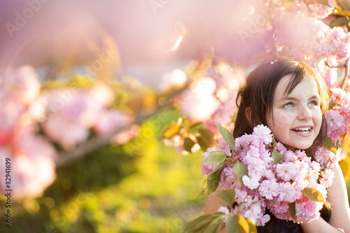 Little girl amid cherry flowering