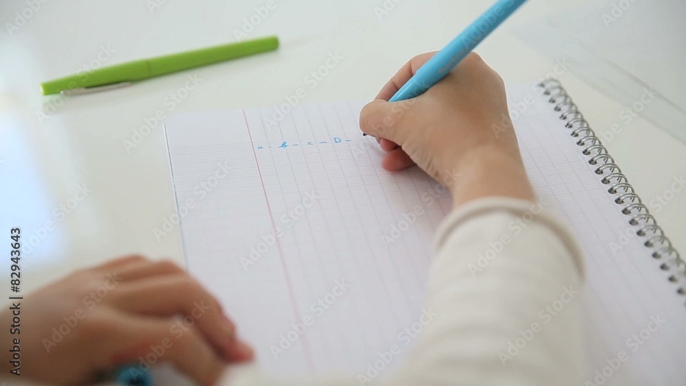Closeup of hand writing alphabet on notebook page Closeup of hand writing alphabet on notebook page