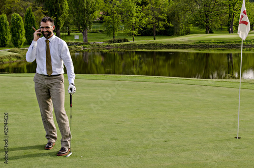 Businessman on phone while playing golf