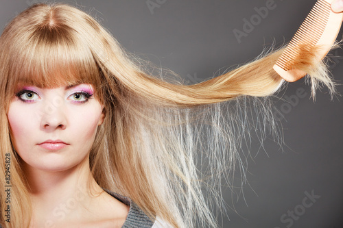 Blonde woman with her damaged dry hair.