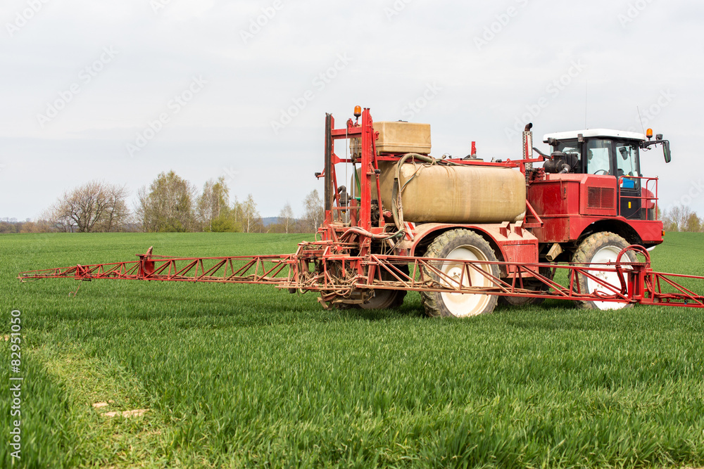Obraz premium Spraying the herbicides on the green field