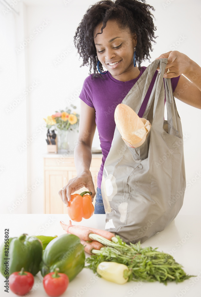 African woman unpacking groceries Stock Photo | Adobe Stock