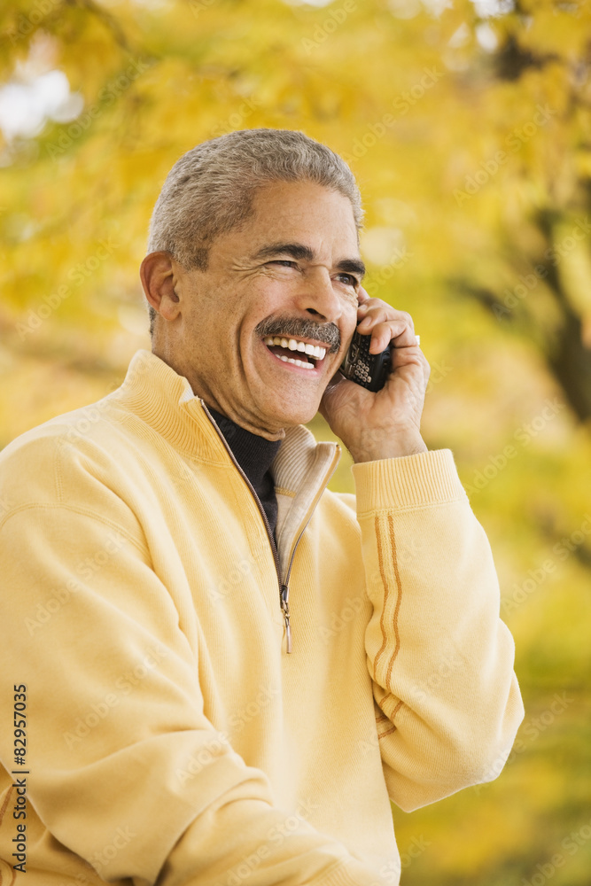 African man using cell phone outdoors in autumn African man using cell phone outdoors in autumn