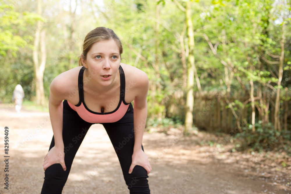 young woman catching her breath while out running young woman catching her breath while out running